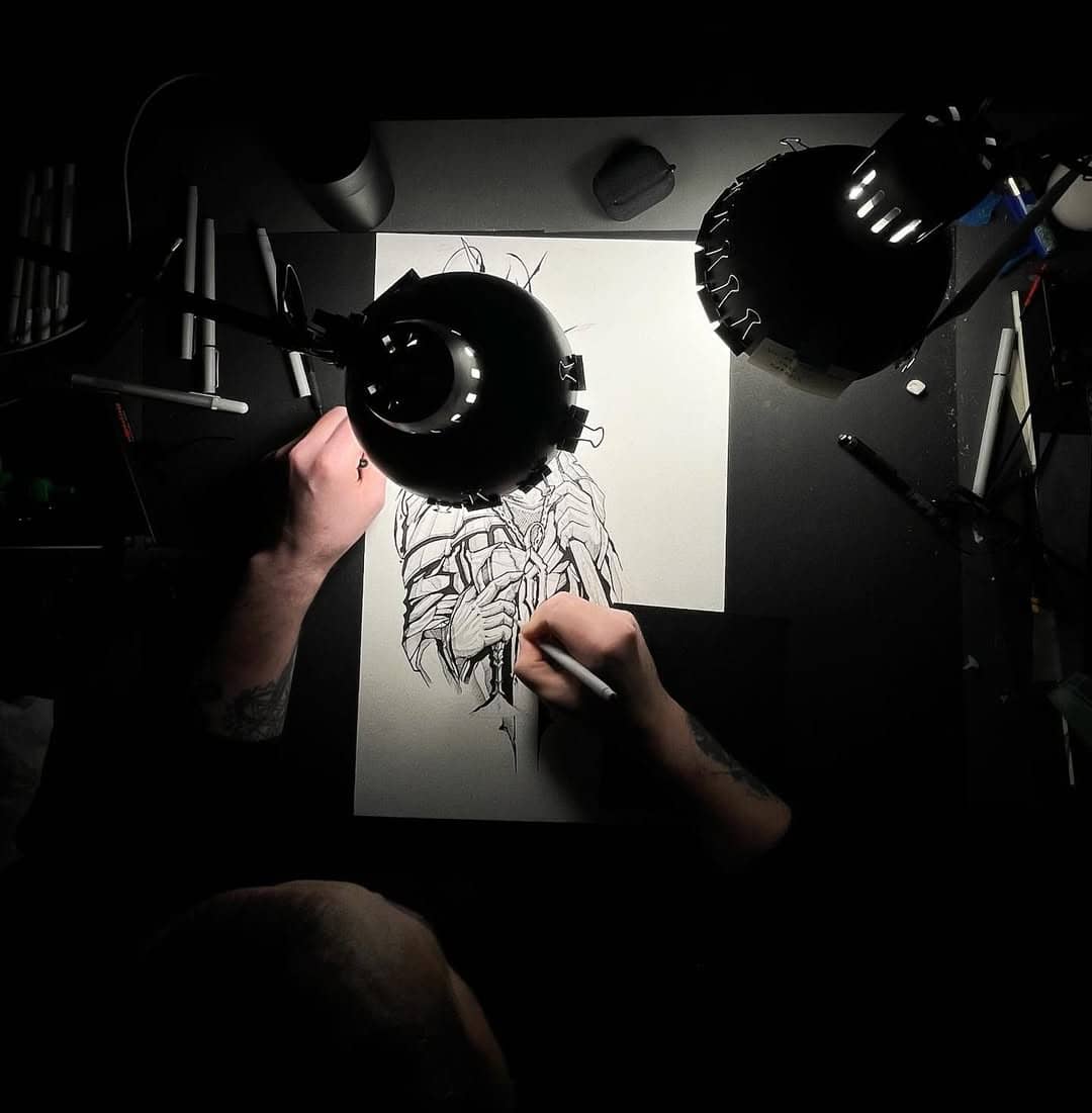 Emil Cwik rysujący projekt tatuażu przy biurku w Sztorm Tattoo Gdańsk