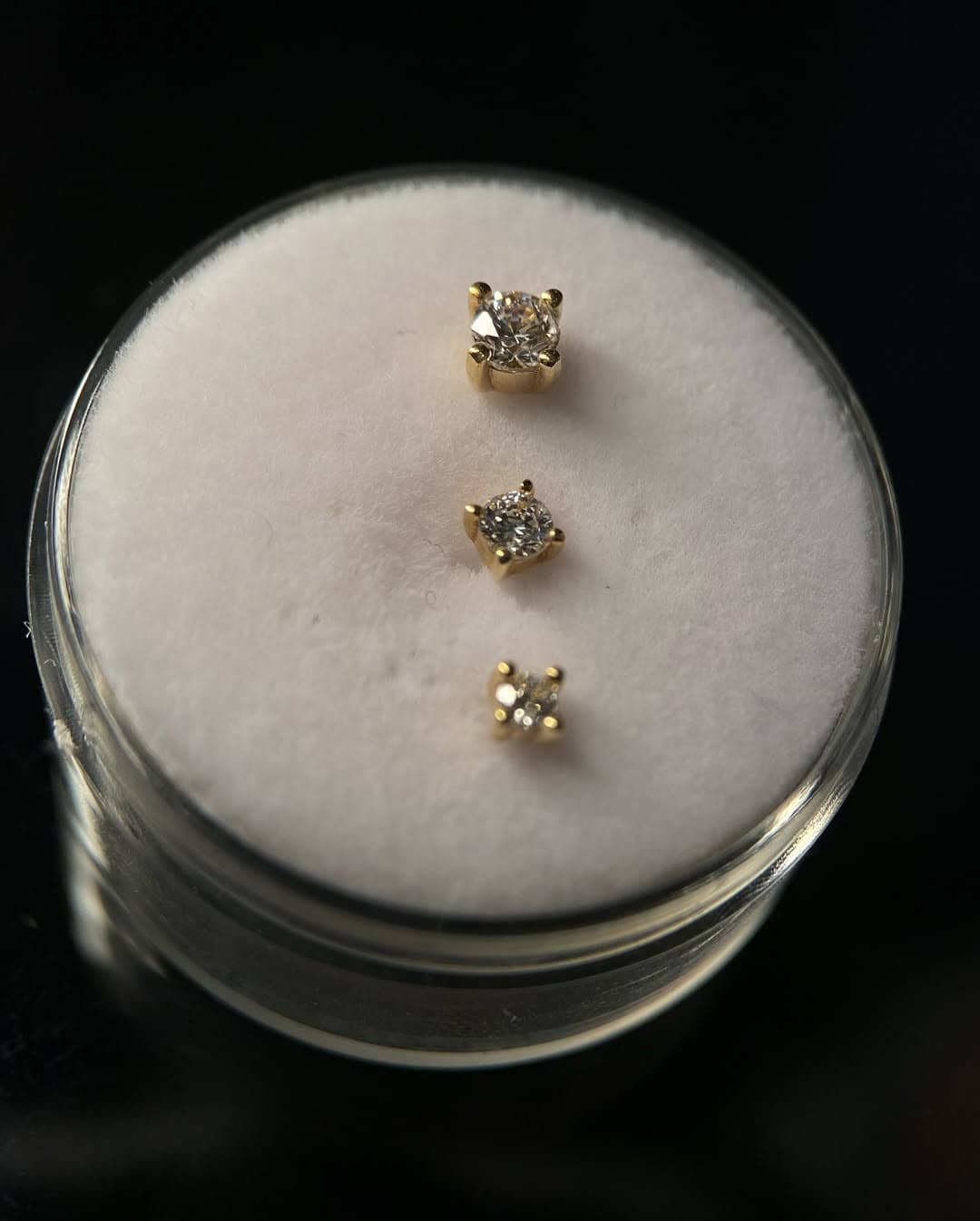 Złota biżuteria do piercingu z kryształami i wiszącymi łańcuszkami – studio Sztorm Tattoo Gdańsk.