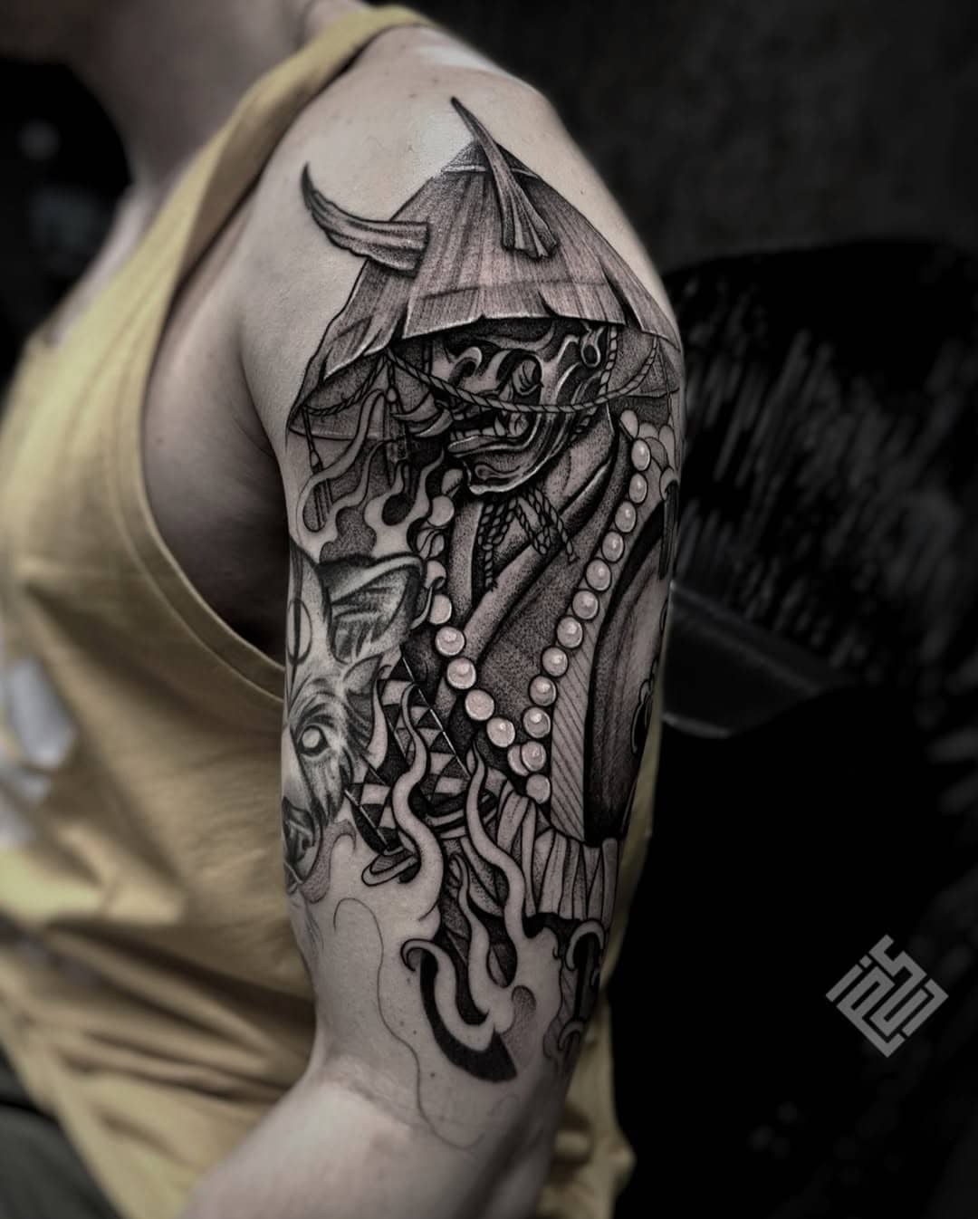 Tatuaż samuraj w masce z kataną i naszyjnikiem, czarny styl, ramię, Sillou, Sztorm Tattoo Gdańsk
