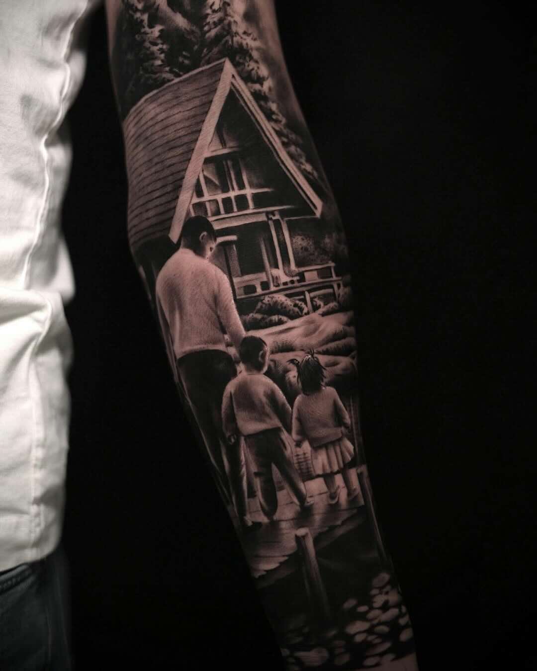Tatuaż realistyczny przedstawiający rodzinę spacerującą przy domku w lesie, wykonany w czerni i szarościach przez Kolosa, Sztorm Tattoo Gdańsk